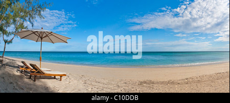 Panorama-Liegestuhl und Sonnenschirm auf dem weißen Sandstrand mit Blick auf die Lagune Stockfoto