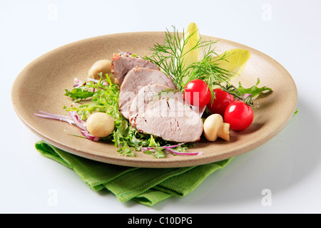 Gebratenes Schweinefilet mit Gemüse und Pilzen serviert Stockfoto