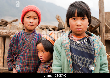 Zwei Schwestern und einen Bruder stand vor ihrer Farm an einem kalten Wintertag in den Bergen von zentral-Bhutan. Stockfoto