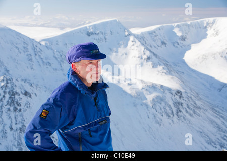 Ein Bergsteiger mit Blick auf die Engel Peak und Braeriach über den Lairig Ghru vom Gipfel des Ben Macdui Stockfoto