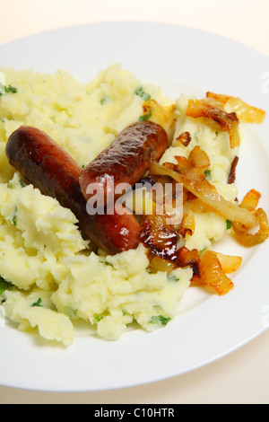 Traditionelle britische "Bangers and Mash" essen Würstchen mit Kartoffelbrei Petersilienkartoffeln und karamellisierten Zwiebeln auf einem Teller. Stockfoto