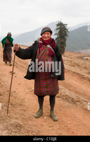 Älterer bhutanischen Mann und seine Frau entlang eines Feldwegs in den Hochländern von Bhutan in traditioneller Tracht Stockfoto