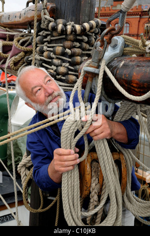 Seemann mit Seil und Ausrüstung auf einem alten Segelschiff Stockfoto