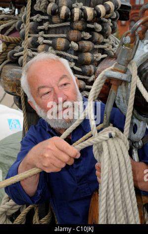 Seemann mit Seil und Ausrüstung auf einem alten Segelschiff Stockfoto