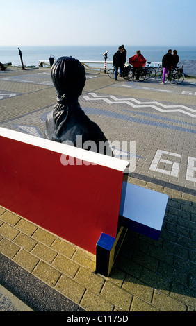 Weibliche Bronzefigur sitzen auf einem rot lackierten Steinbank an der Strandpromenade, der Maler Piet Mondrian-Denkmal Stockfoto