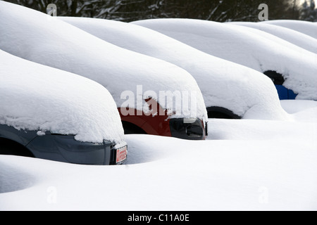 Verschneite Autos auf einem Parkplatz in Langenhahn, Rheinland-Pfalz, Deutschland, Europa Stockfoto