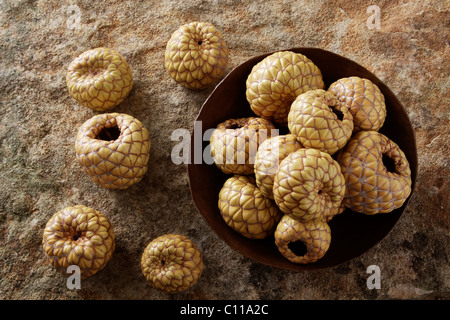 Salak (Salacca Zalacca), Obst, in einer kupfernen Schüssel auf eine Steinoberfläche Stockfoto