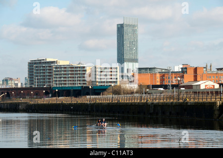 Ruderer auf dem Fluss Irwell mit dem Beetham Tower (Hilton Tower) hinter Manchester, England, Vereinigtes Königreich Stockfoto