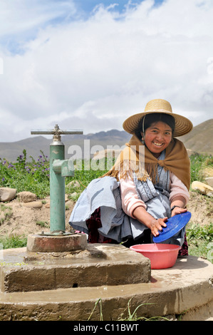 Frauen in traditioneller Tracht des Quechua Abwasch am Brunnen, bolivianischen Altiplano Hochland, Departamento Oruro, Bolivien Stockfoto