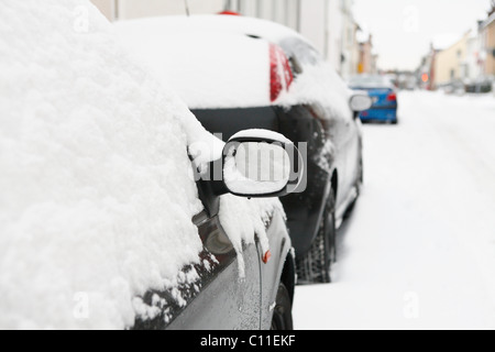 Spiegel rechts der schneebedeckte schwarzes Auto und schneebedeckte Straße, Winter, Deutschland Stockfoto