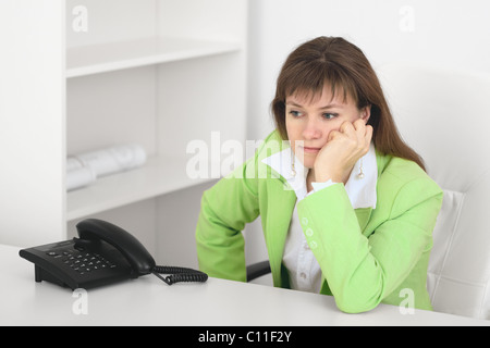 Müde Manager spiegelt im Büro sitzen am Tisch Stockfoto