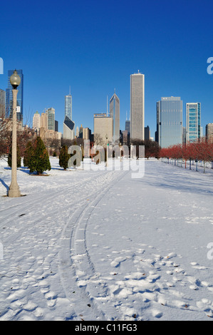 Ein Schnee Grant Park weg mit Spuren, die zu einem Blick auf einen Teil der North Loop skyline abgedeckt. Chicago, Illinois, USA. Stockfoto