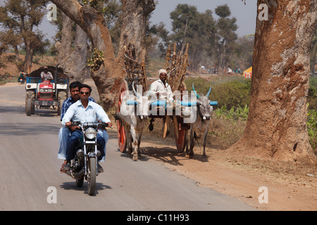 Verkehr mit Motorrad, Ochsenkarren und Traktor auf Landstraße, Karnataka, Südindien, Indien, Südasien, Asien Stockfoto
