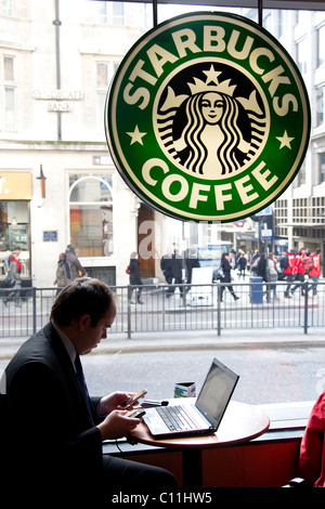 Stadt-Arbeiter auf Laptop in Starbucks Café Denkmal London. Foto: Jeff Gilbert Stockfoto