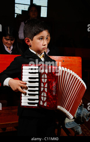 Junge Akkordeon zu spielen, während Gottesdienst, Bergbau Stadt Lota, Chile, Südamerika Stockfoto