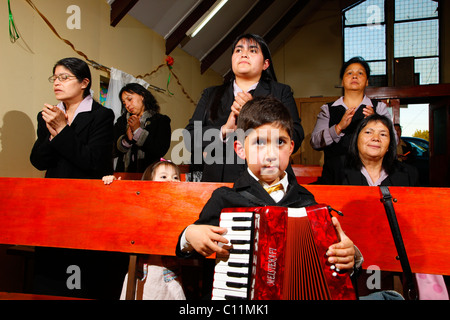 Junge Akkordeon zu spielen, während Gottesdienst, Bergbau Stadt Lota, Chile, Südamerika Stockfoto