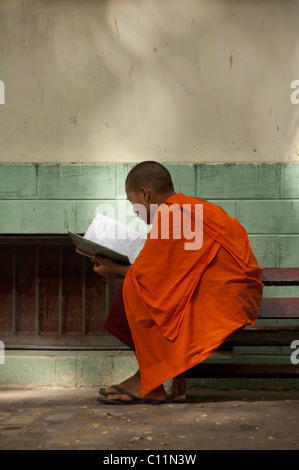 Myanmar (aka Burma), Mandalay, Amarapura. Mahagandayone Kloster, das größte Kloster in Myanmar. Mönch zu lesen. Stockfoto