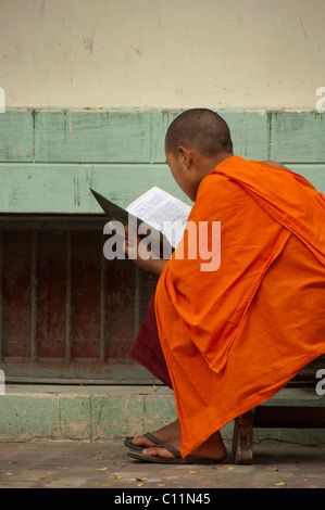 Myanmar (aka Burma), Mandalay, Amarapura. Mahagandayone Kloster, das größte Kloster in Myanmar. Mönch zu lesen. Stockfoto