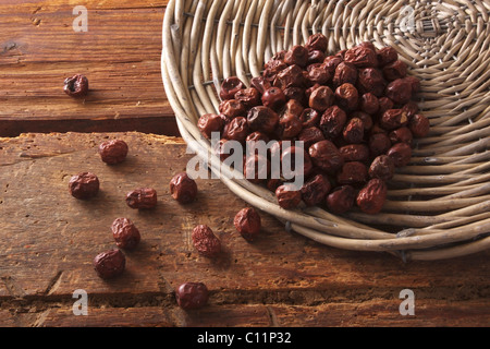 Getrocknete Beeren der Jujube (Ziziphus Jujuba) als Zutat für Müsli, Kuchen und Gebäck, aus einer Weide Korb gekippt