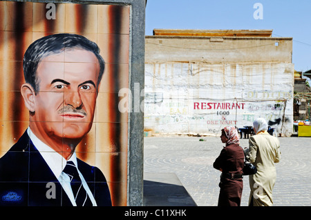 Fliesen mit einem Porträt des ehemaligen Präsidenten Hafez al Assad, und Frauen mit Kopftüchern, Bosra, Syrien, Asien Stockfoto