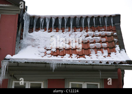 Eiszapfen auf dem Dach eines Hauses Stockfoto