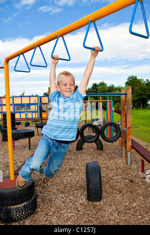 Junge, fünf Jahre alt, auf einem Spielplatz, Klettern Stockfoto