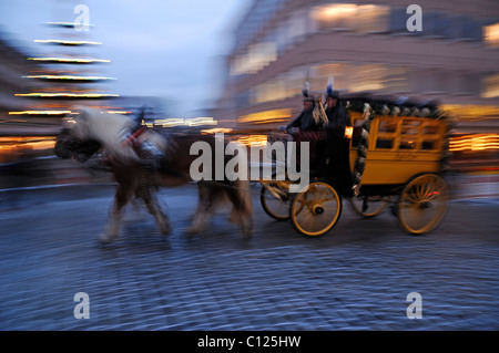 Wischen Sie Schuss von der alten Postkutsche mit Pferde galoppieren auf der Fleischbruecke-Brücke während des Christkindlesmarktes Weihnachten Stockfoto