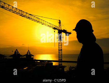 Baukran und Bauarbeiter am Sonnenuntergang, Thailand, Asien Stockfoto