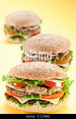 Drei leckeren Hamburger auf gelbem Hintergrund Stockfoto