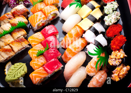 Verschiedene japanische Sushi auf einer schwarzen Platte. Stockfoto