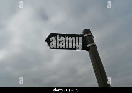 Ein öffentlicher Fußweg Wegweiser im Vereinigten Königreich mit einem dunklen Himmel im Hintergrund. Stockfoto