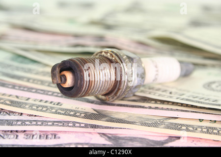 alte rostige Zündkerze auf viele Dollarscheine Stockfoto