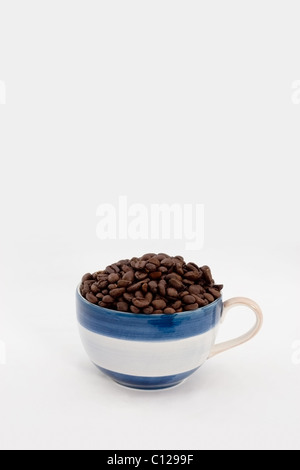 Espressotasse voll mit coffebeans Stockfoto