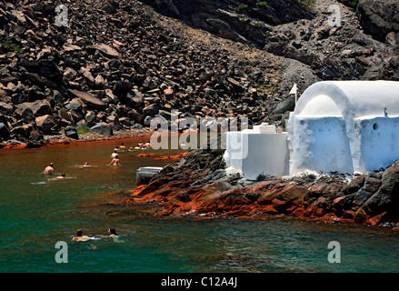 Menschen schwimmen in den Thermalquellen von Palaia ("alten") Kameni Insel, im Herzen der Caldera von Santorini, Griechenland. Stockfoto