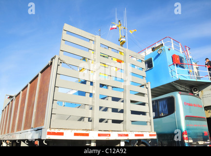 Blauer Himmelsblick auf Tier-Carrier LKW und Cruz del Sur Turibus auf dem Deck ein Kanal von Chacao Autofähre, Südchile Stockfoto