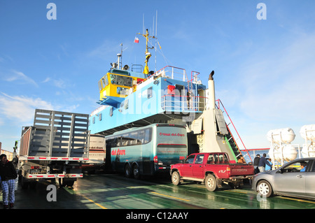 Blauer Himmelsblick auf grüne Parkdeck mit Autos Busse LKW und Passagiere auf einem Kanal von Chacao Autofähre, Chiloé Insel, Chile Stockfoto