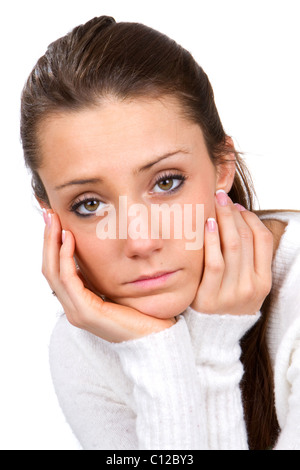 Sad faced young woman holds her face in her hands. Stockfoto