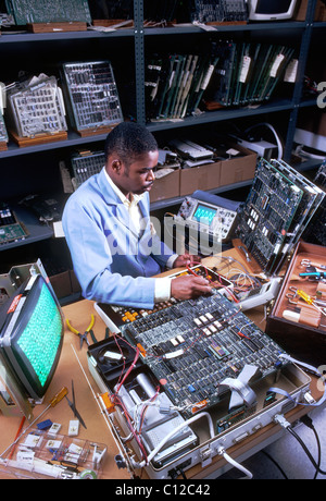 Afrikanische amerikanische Techniker inspiziert Leiterplatten an einem Computer Produktionsstätte. Stockfoto