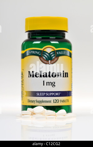 Flasche Spring Valley Melatonin Nahrungsergänzungsmittel mit Tabletten auf weißem Hintergrund verstreut, Ausschnitt. Stockfoto