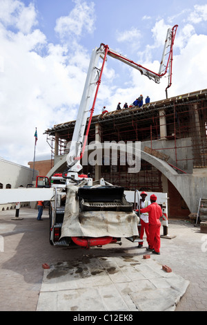 Beton Pumpen am Bau mit einem Gelenkarm gespeist von einem konkreten Fahrzeug in der zweiten Etage eines Gebäudes reicht von einem konkreten Fahrzeug Website Stockfoto