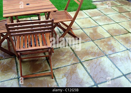 Gartenmöbel aus Holz auf Terrasse im Regen Stockfoto