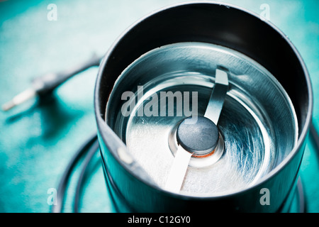 Leere elektrische Kaffeemühle Maschine auf dem grünen Tisch (ohne Deckel) Stockfoto