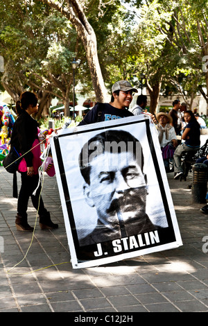 lächelnde junge mexikanische sozialistischen in Baseball-Kappe hält überdimensionale Poster von Josef Stalin auf KPD Kundgebung in Oaxaca Zocalo Stockfoto