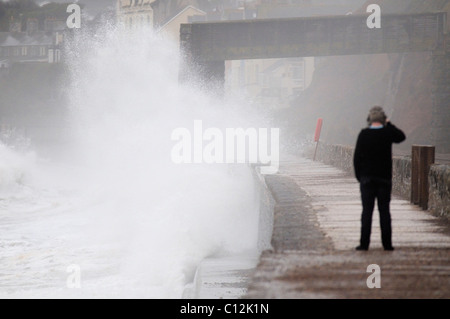 Junger Mann die Fotos von dem Meer plantschen gegen den Deich in Dawlish in Devon Stockfoto