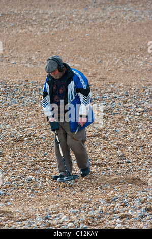 Mann an einem Strand mit einem Metalldetektor Stockfoto