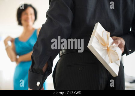 USA, New Jersey, New Jersey City, Man versteckt sich hinter seinem Rücken-Geschenk-box Stockfoto