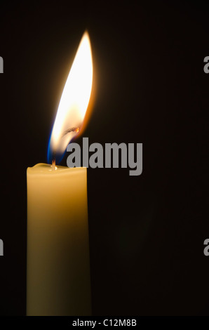 Brennende Kerze auf schwarzem Hintergrund Stockfoto