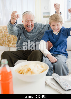 USA, New Jersey, Jersey City, Großvater und Enkel (8-9) vor dem Fernseher und jubeln Stockfoto