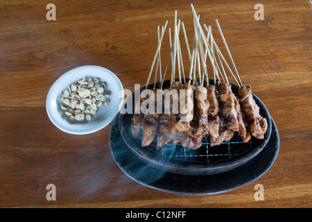 Chicken Satay Kochen am Tisch auf einem Miniatur-Holzkohle-Grill in Bali Indonesien Stockfoto