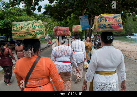 Frauen, die Körbe mit Tempelopfern zu einem Festival in Padang Bai auf bali Stockfoto